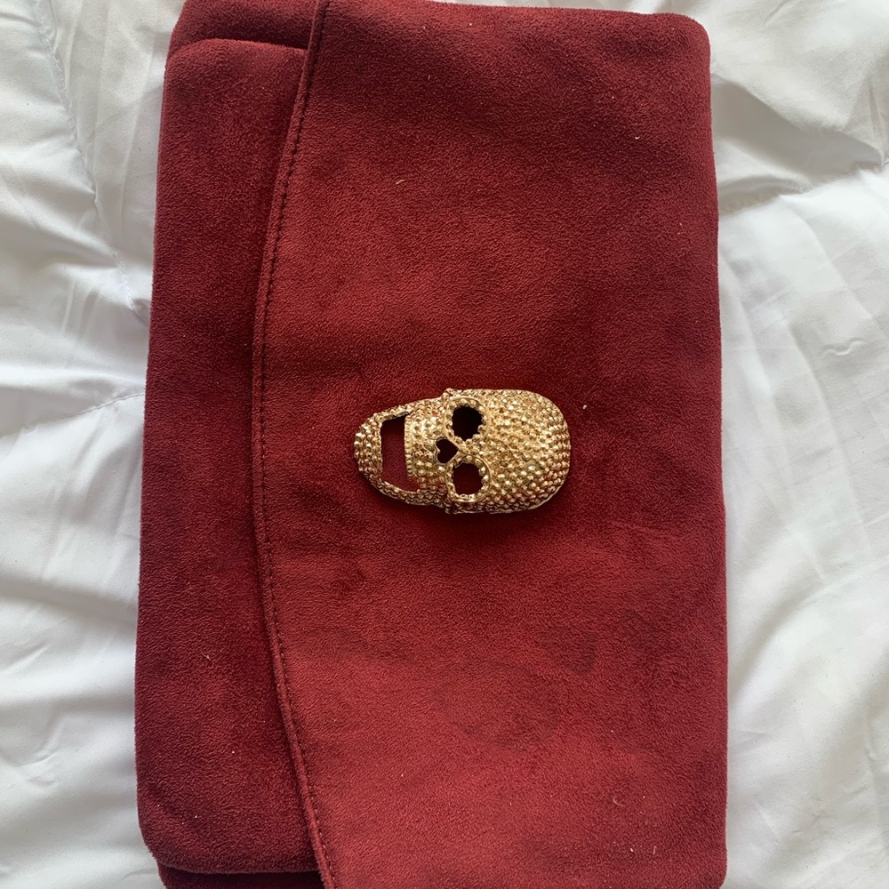 Maroon suede clutch with gold skull